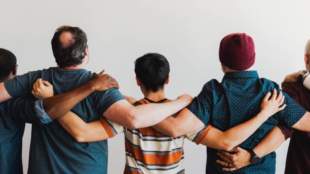 istock Diverse group of people standing together, arms linked. 2181475535