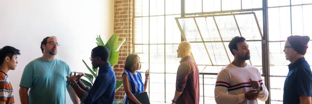 istock Diverse group of people talking in a bright room. 2181475550