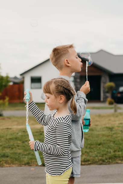 istock Children blow suds together playing on cottage backyard 2181480222