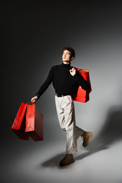 istock Handsome young man joyfully showcasing shopping bags in a studio during Black Friday 2181480925