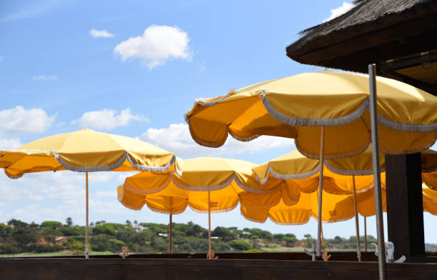 istock Yellow umbrellas on a terrace against clear blue sky 2181485109