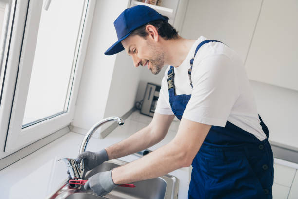 istock Skilled handyman in blue overalls fixing kitchen faucet with tools, demonstrating expertise in home plumbing and maintenance tasks 2181487883