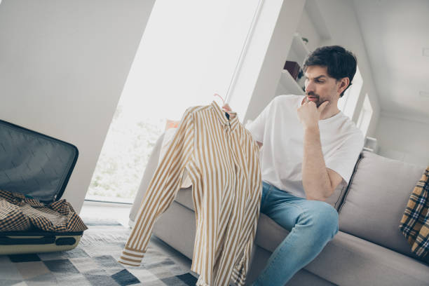 istock Young man deciding on casual attire while relaxing at home during the weekend 2181488883