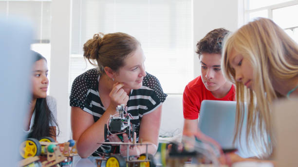 istock Students With Female Teacher In School Computer Class Building And Programming Robot Vehicle 2181490225
