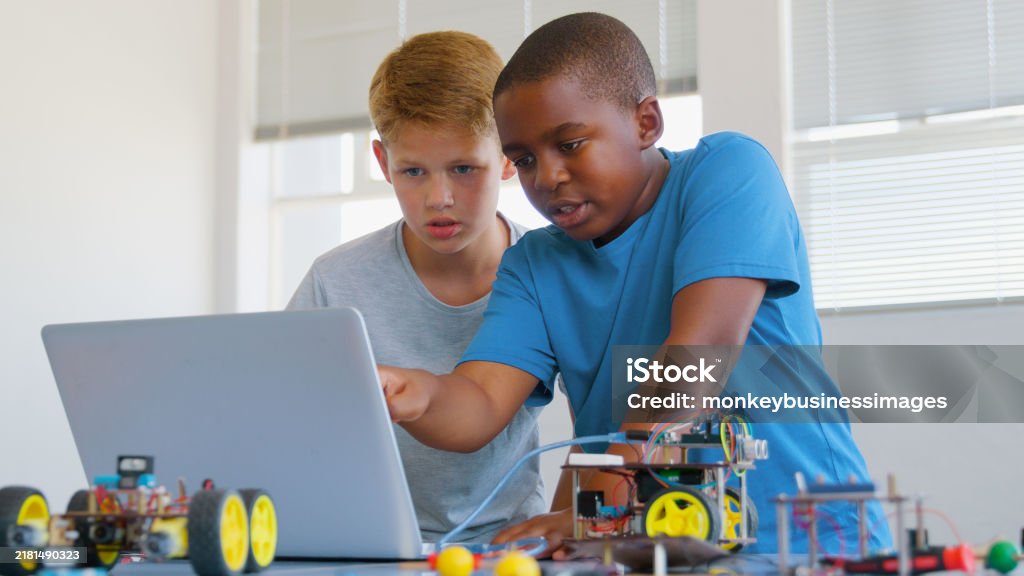 Two Male Students Building And Programming Robot Vehicle In After ...