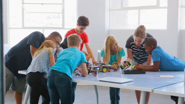 istock Students With Male And Female Teachers In School Computer Class Making And Programming Robot Vehicle 2181490380