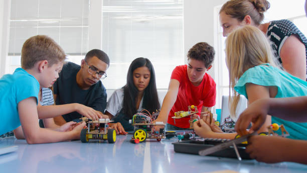 istock Students With Male And Female Teachers In School Computer Class Making And Programming Robot Vehicle 2181490453
