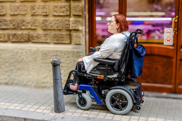 istock Electric Wheelchair User Navigating Urban Sidewalk Barriers 2181490974