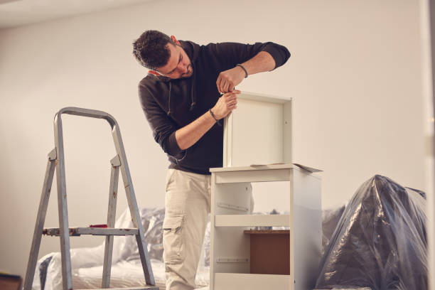 istock Man working and assembling furniture in a new apartment. 2181494917