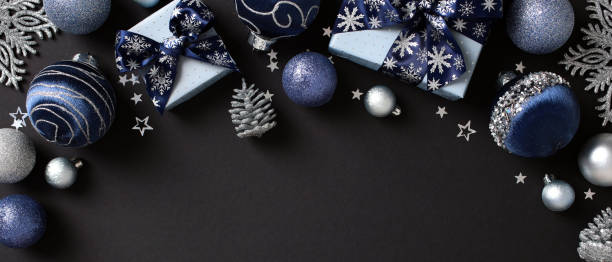 istock Blue and silver Christmas decorations with baubles, gift boxes, snowflakes, and pine cones on a black background. Perfect for holiday-themed content and festive promotions 2181495359