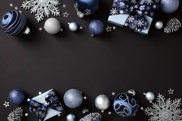 istock Elegant Christmas decor in blue and silver on dark backdrop. Includes baubles, gift boxes, pine cones, and snowflakes. Flat lay, top view, copy space 2181495398