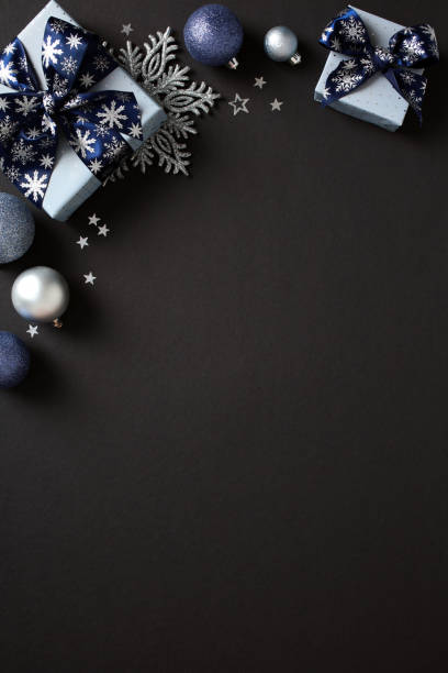 istock Elegant Christmas gift boxes with blue ribbons and festive decorations on a dark background. Ideal for holiday promotions, greeting cards 2181495527