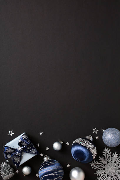 istock Christmas-themed flat lay with blue gift box, silver baubles, and snowflakes on dark background, ideal for festive season promotions and holiday designs 2181495745