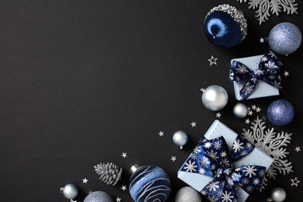 istock Blue and silver Christmas ornaments with baubles, gift boxes, snowflakes, and pine cones on a dark background. Flat lay, top view, copy space. 2181496026