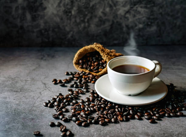 istock Americano coffee cup and roasted coffee beans falling in a burlap sackon gray background, Black coffee cup aromatic 2181496355
