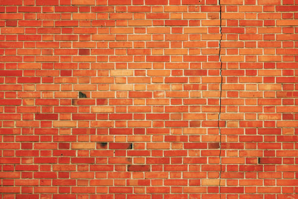 Cracked and damaged brick wall as background and architectural pattern