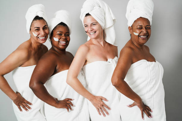 istock Multigenerational women having fun applying face beauty mask with cucumbers on their face - Skin care therapy - Focus on african senior woman face 2181499273