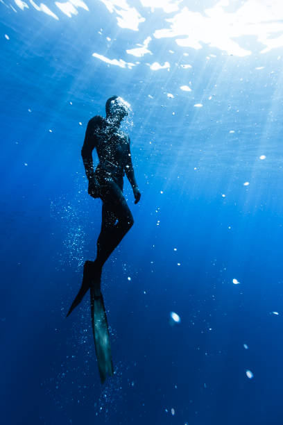 Freediver Swimming in Deep Sea With Sunrays.