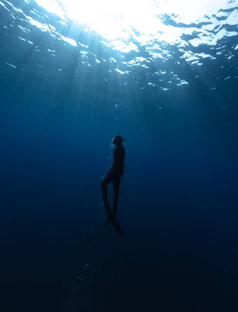 istock Freediver Swimming in Deep Sea With Sunrays. 2181499411