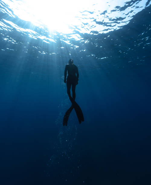 istock Freediver Swimming in Deep Sea With Sunrays. 2181500090