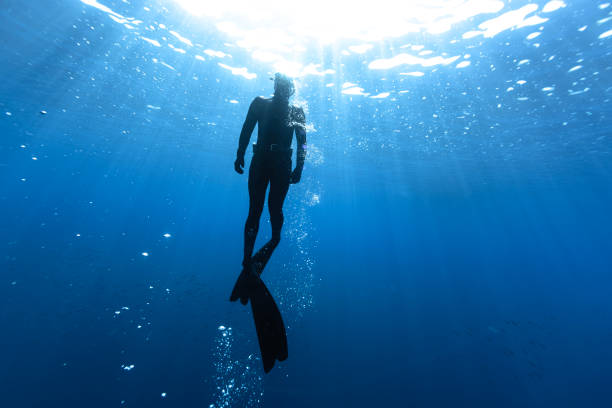 istock Freediver Swimming in Deep Sea With Sunrays. 2181500257