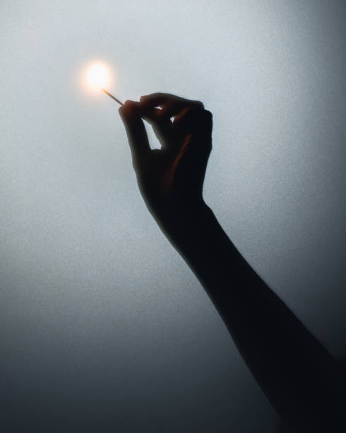 Burning match in hand. Abstract silhouette