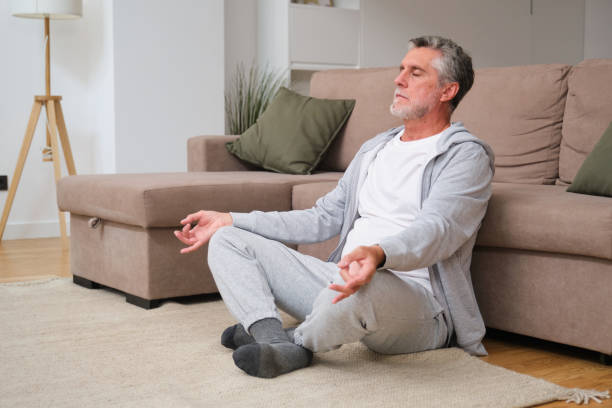 istock Senior man meditating in living room, finding inner peace and mindfulness 2181529835