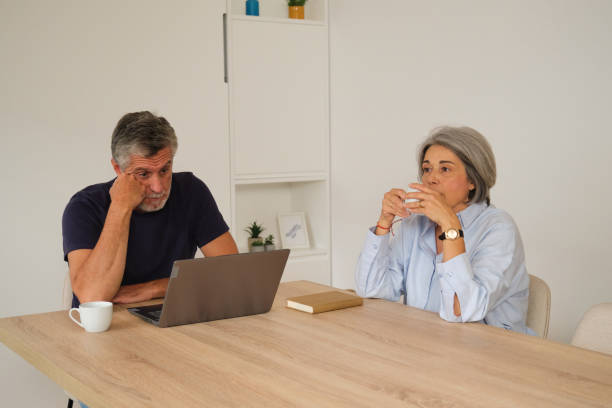istock Senior couple having a serious conversation at home using laptop 2181529884