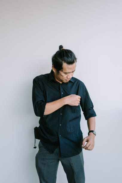 istock Southeast Asian man looking down at his shirt pocket with a curious expression 2181530934