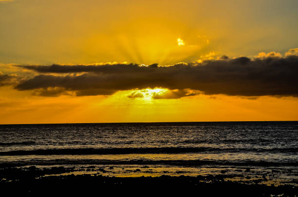 istock The sun is setting over the ocean, casting a warm glow over the water 2181543917