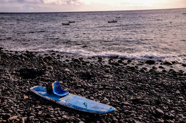 A colourful windsurfing board and sail on a sandy beach in El Medano, Tenerife, Spain.