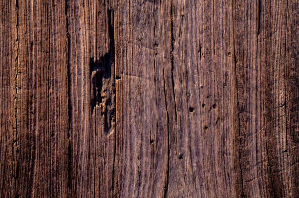 The image is of a wooden surface with a grainy texture. The wood appears to be old and weathered, giving the impression of a natural, rustic feel. The grain of the wood is visible in the image