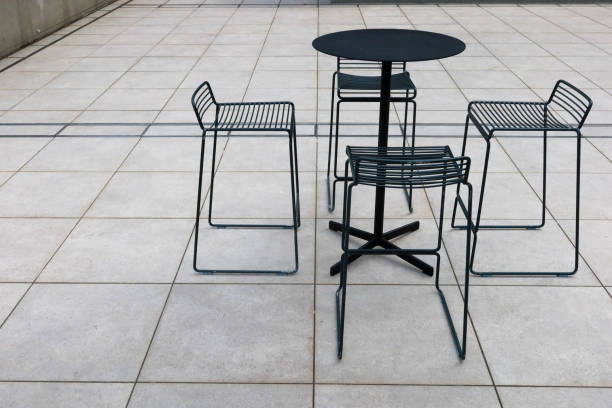 istock vacant high bar black table and four chairs on stone ground 2181547252