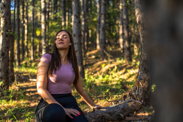 istock Handsome girl resting while sitting on the tree trunk, enjoying with a good vibes and connecting with a nature. 2181548994