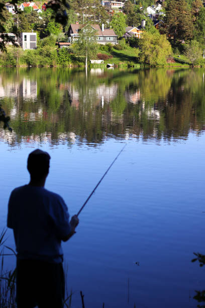 istock fisherman on the lake 2181552391