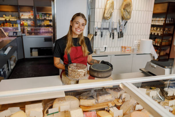 istock A Cheese Specialist is Smiling Joyfully Behind the Counter in a Modern Deli Environment 2181559109