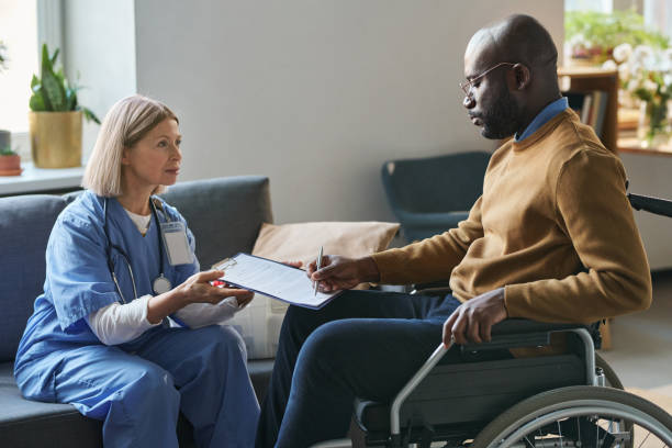istock Black Man with Disability Signing Medical Form 2181559353