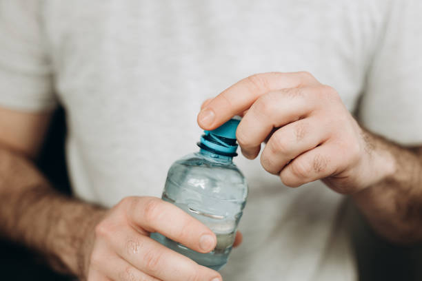 istock man's hand holding a plastic bottle of water 2181559562