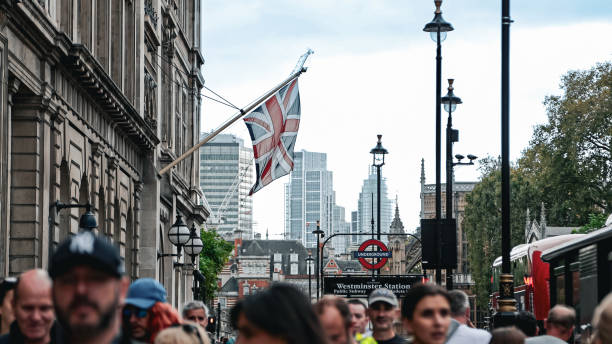 Man stands on London skyline with Union Jack t-shirt and matching sunglasses