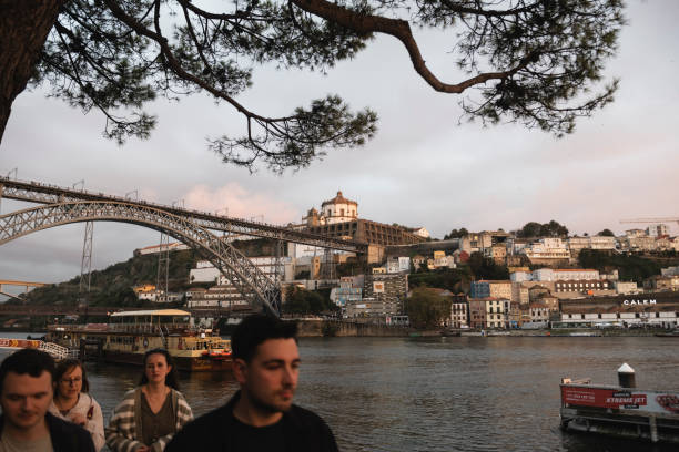 Porto, Portugal - October 21, 2024: Pedestrians walk along the riverfront on Cais da Ribeira in Porto.
