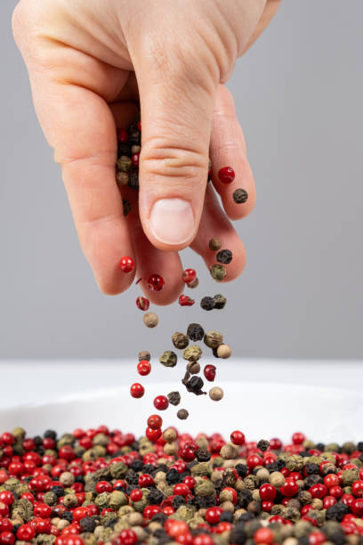 istock Hand sprinkling peppercorn mixture red, green, white and black pepper 2181561703