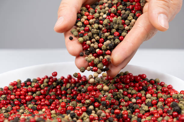 istock Hands sprinkling peppercorn mixture red, green, white and black pepper 2181561714