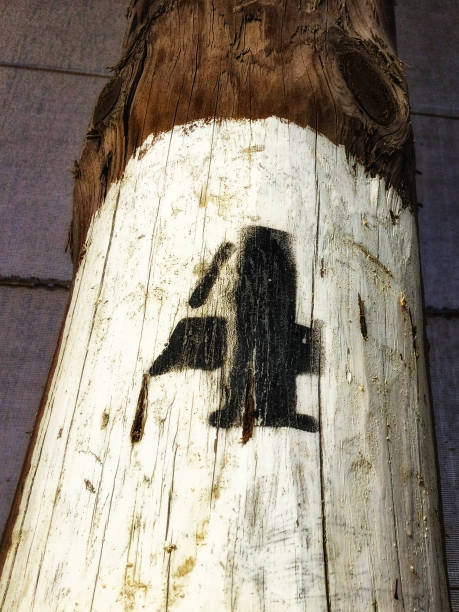 A wooden cross with a green metal bracket. The cross is made of wood and has a green metal bracket