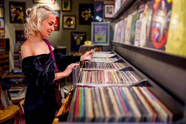 istock Young woman browsing vinyl records in a retro-style record store. 2181564149