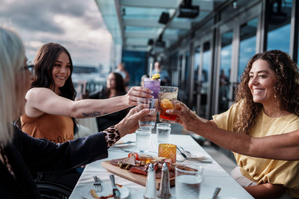 Multiracial group of women having dinner and toasting with non-alcoholic drinks