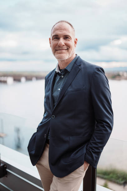 istock Handsome mature adult man on rooftop terrace overlooking river 2181567010