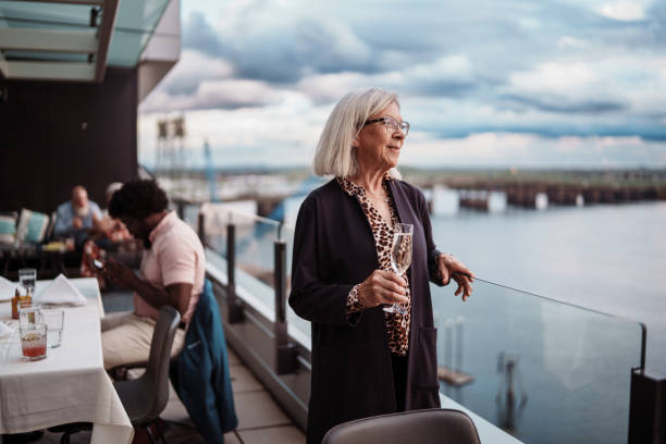 istock Gorgeous senior woman enjoying dinner and drinks with a riverfront view 2181567035