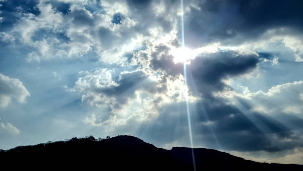 istock Sunlight passing through fluffy coluds sky to the mountain silhouette 2181568132
