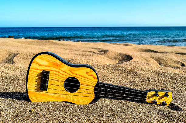 istock A small wooden guitar is laying on the sand on a beach 2181568652