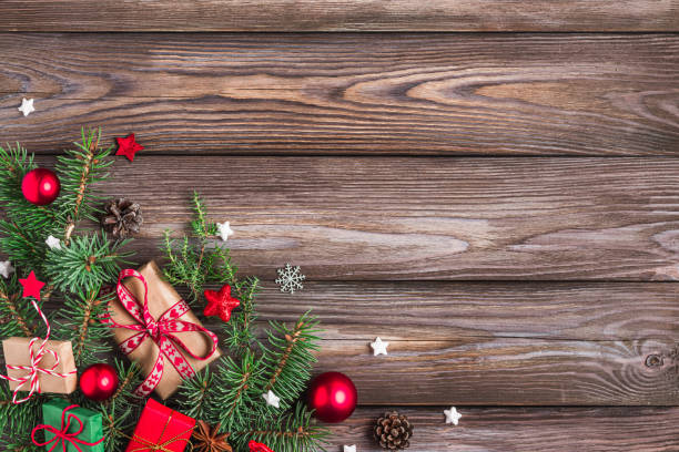 istock Christmas background with fir branches, gift boxes, red decorations, candy and pine cones on rustic wooden table. Flat lay. Happy New Year and winter holidays background. Top view with copy space 2181569303